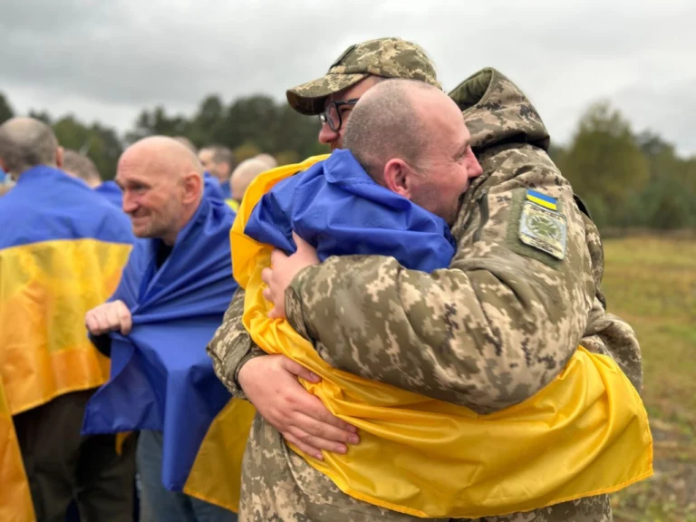 Обійми українських військових під час обміну полоненими — звільнені захисники з державними прапорами
